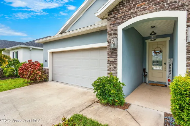 a front view of a house with plants