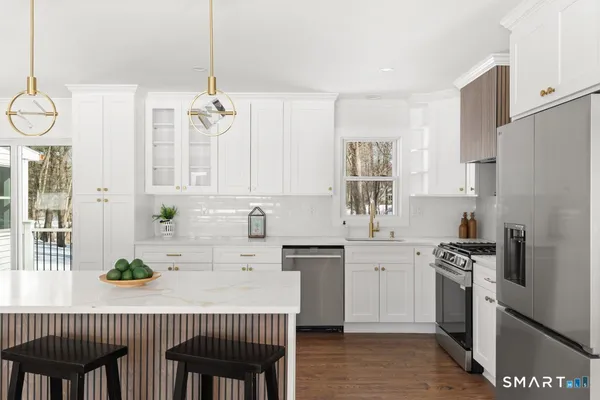 a kitchen with stainless steel appliances a sink a stove a refrigerator and cabinets