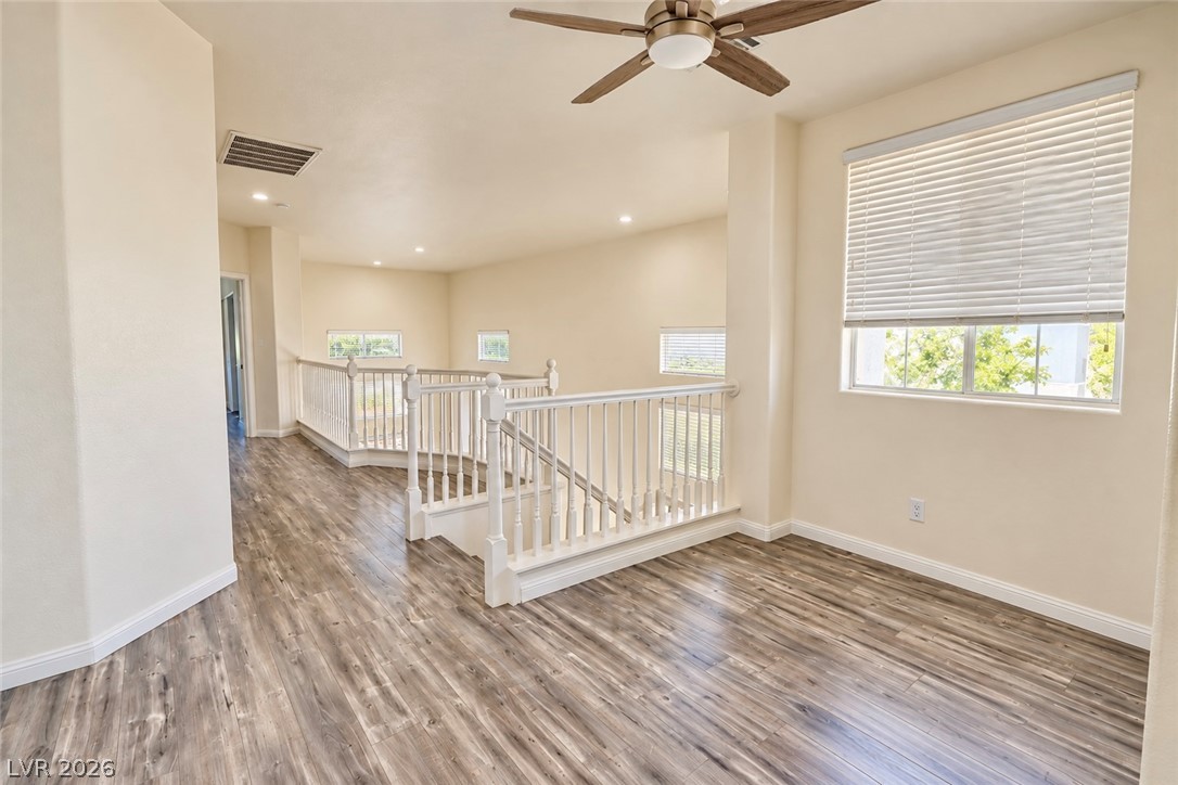 3104 Maple Ridge Court Henderson, NV 89052 - Photo 15 of 25 Sunlight streams across the polished wood-style flooring of this versatile upper-level landing space.