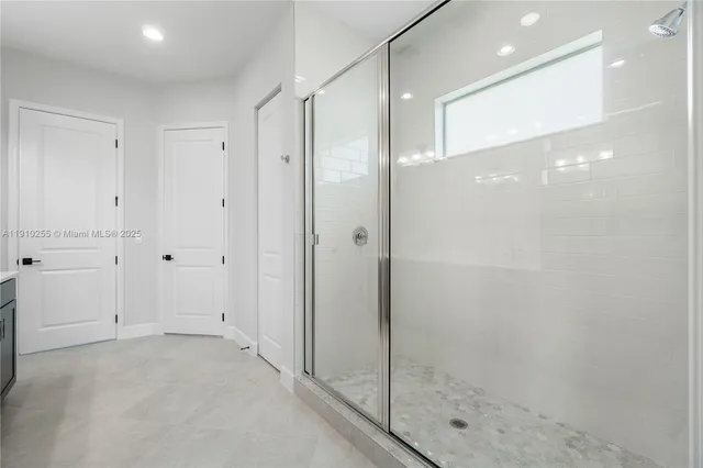 a bathroom with a shower and a glass door