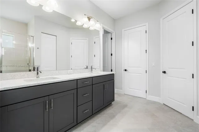 a bathroom with double vanity sinks and a mirror