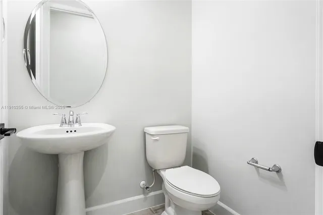 a bathroom with a toilet a sink and mirror