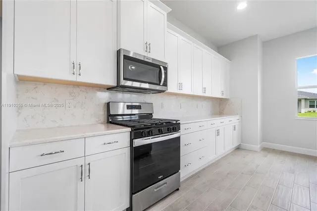 a kitchen with white cabinets and stainless steel appliances