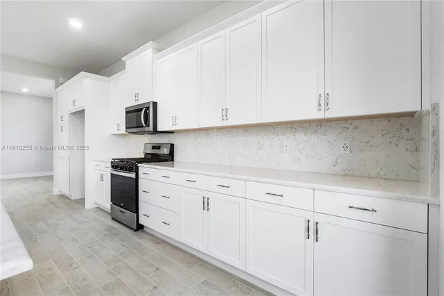 a kitchen with white cabinets and white appliances