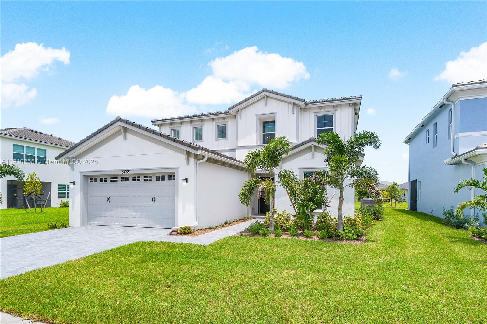 5488 Liberty Lane, Unit 5488 Westlake, FL 33470 - Photo 3 of 39 a view of a white house with a big yard and potted plants