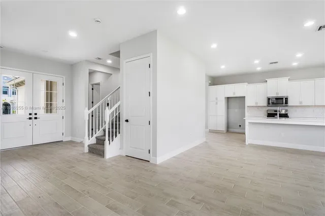 a view of a kitchen with a sink and dishwasher a refrigerator with wooden floor