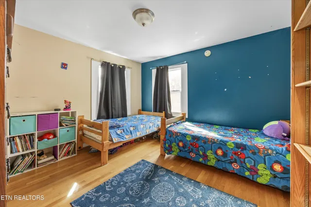 a bedroom with a bed and wooden floor