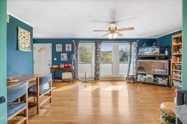 a living room with furniture a flat screen tv and floor to ceiling window