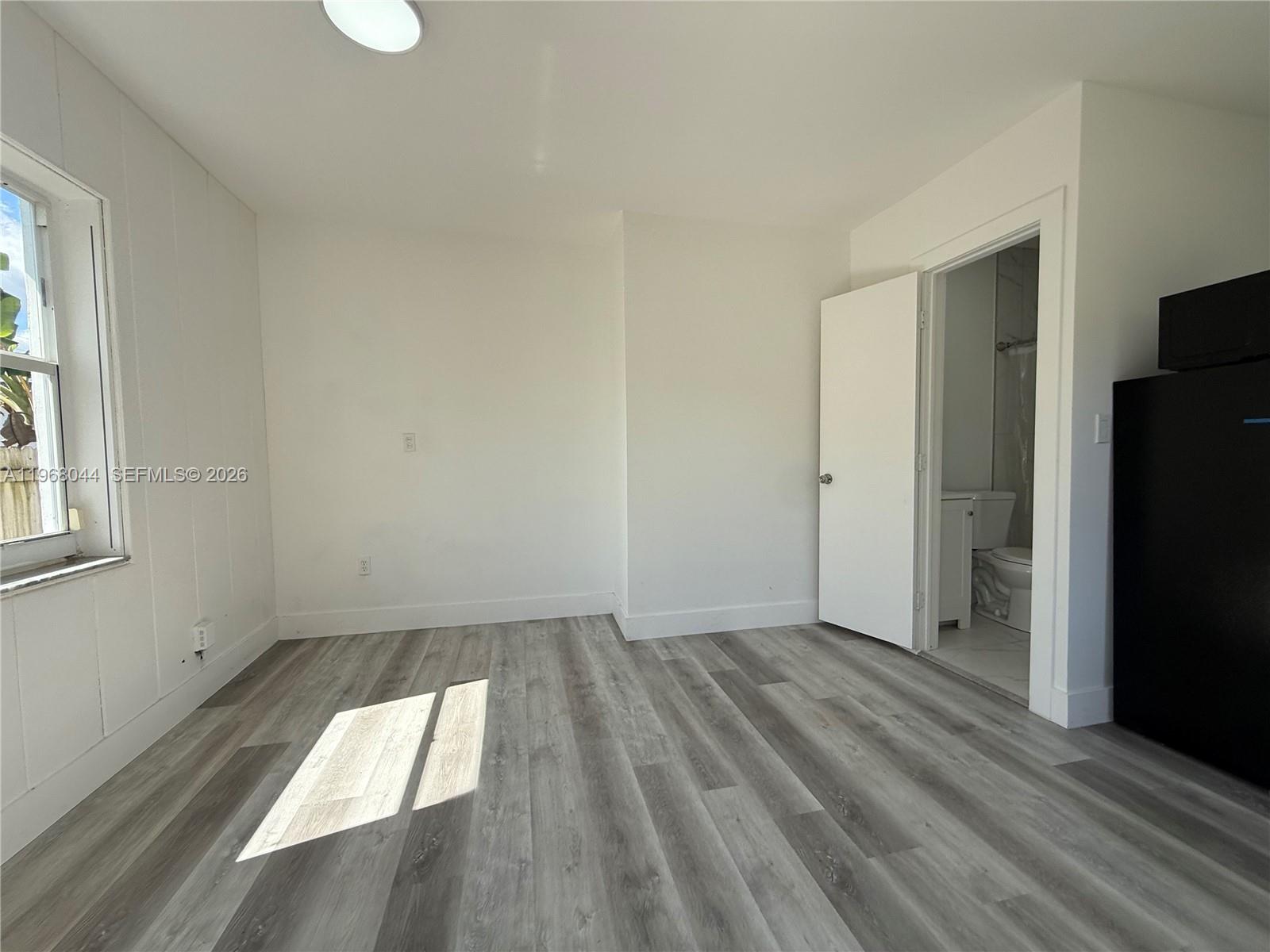 2801 Southwest 26th Street, Unit RLEFT Miami, FL 33133 - Photo 3 of 10 wooden floor in an empty room with a window