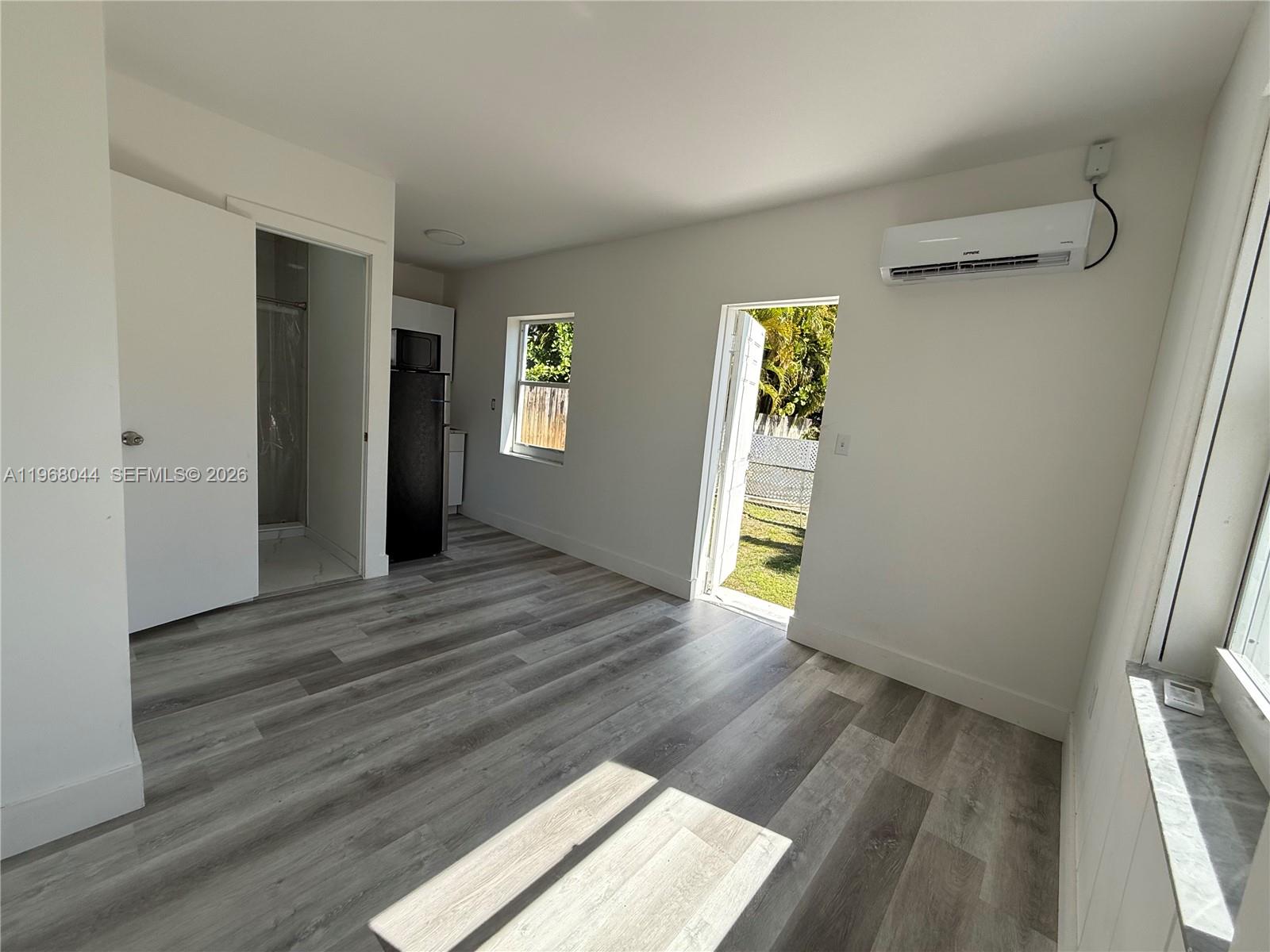 2801 Southwest 26th Street, Unit RLEFT Miami, FL 33133 - Photo 5 of 10 an empty room with wooden floor and windows