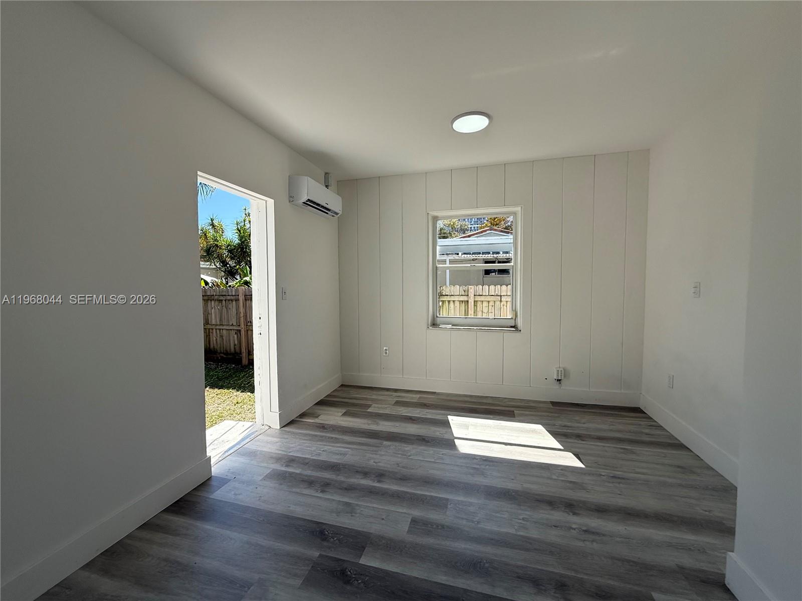 2801 Southwest 26th Street, Unit RLEFT Miami, FL 33133 - Photo 6 of 10 an empty room with wooden floor and windows
