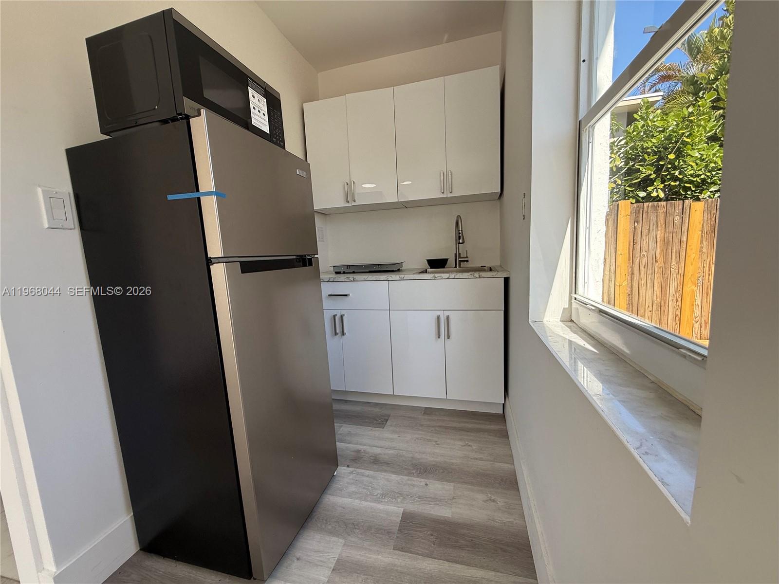 2801 Southwest 26th Street, Unit RLEFT Miami, FL 33133 - Photo 7 of 10 a kitchen with stainless steel appliances a refrigerator and a window