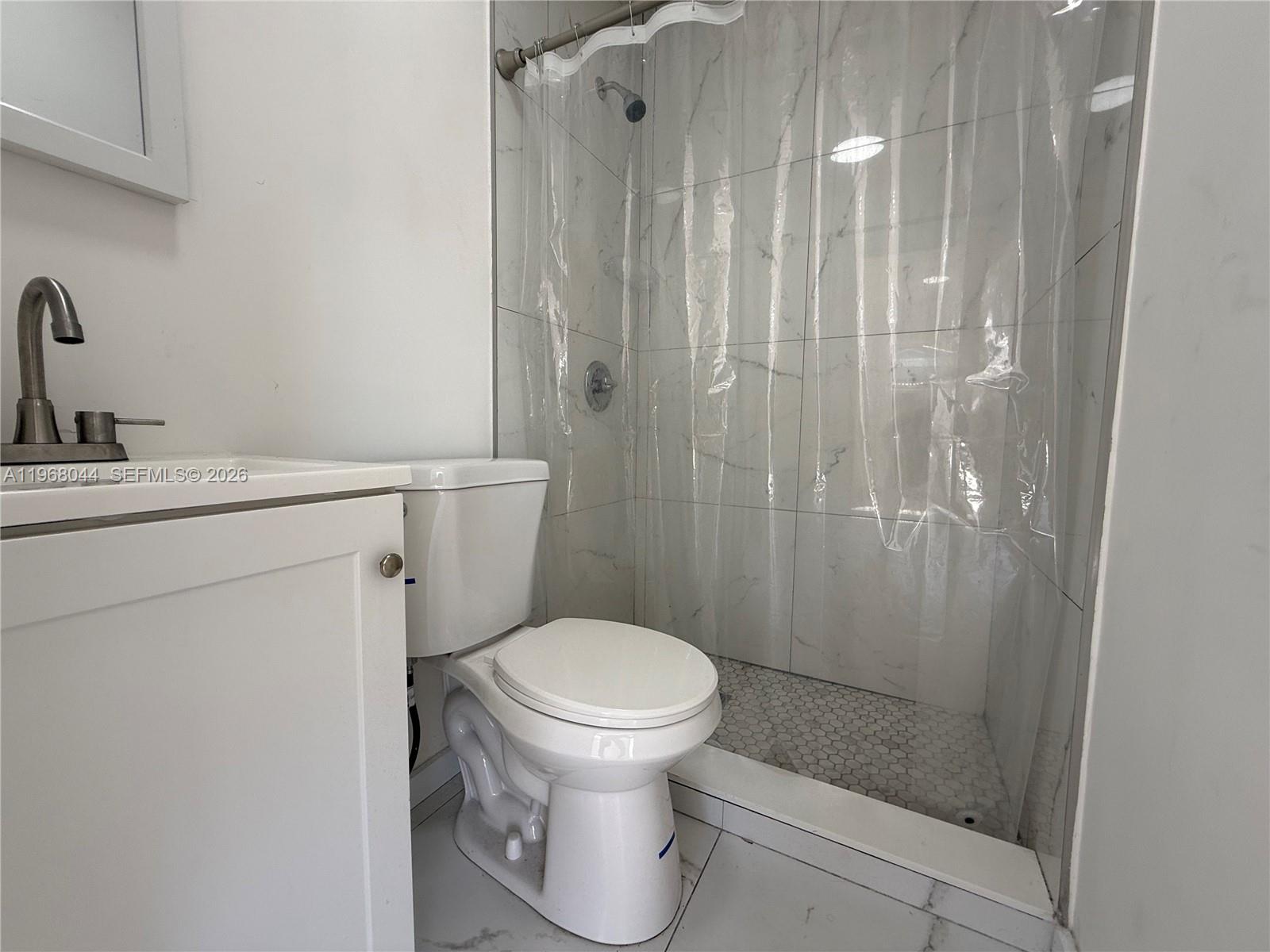 2801 Southwest 26th Street, Unit RLEFT Miami, FL 33133 - Photo 8 of 10 a bathroom with a toilet sink and shower