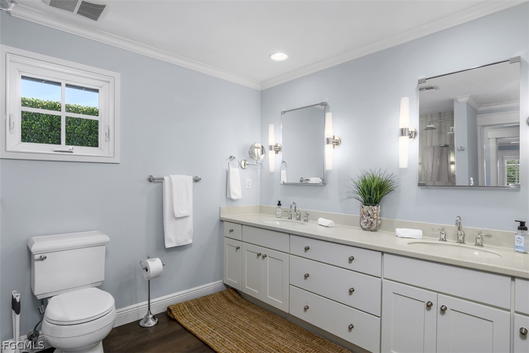 549 7th Avenue North Naples, FL 34102 - Photo 12 of 19 a bathroom with a granite countertop toilet a sink a mirror and a window
