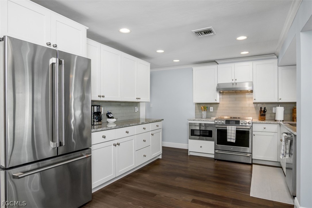 549 7th Avenue North Naples, FL 34102 - Photo 9 of 19 a kitchen with stainless steel appliances and white cabinets