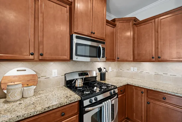 a kitchen with granite countertop a stove top oven microwave and cabinets