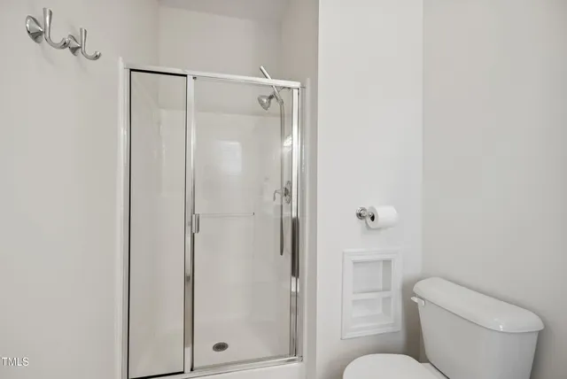 a bathroom with a toilet and a shower