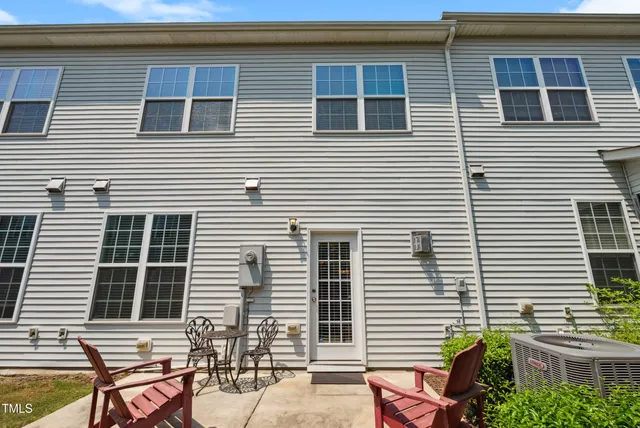 a view of a house with chairs and table in a patio