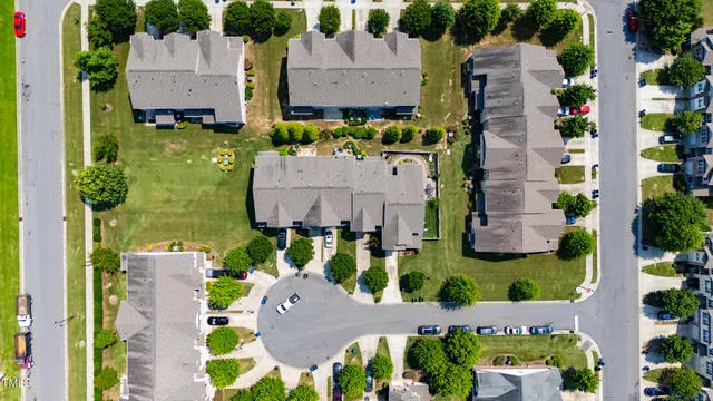 an aerial view of residential houses with outdoor space and parking