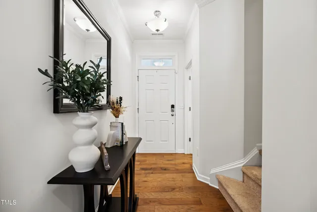 a view of a hallway with table and front door