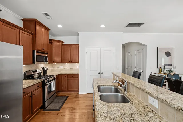a kitchen with stainless steel appliances granite countertop a sink stove and refrigerator