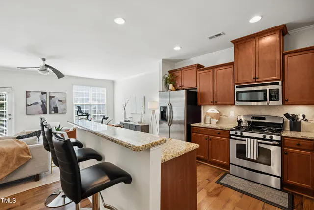a large kitchen with stainless steel appliances kitchen island granite countertop a sink and cabinets