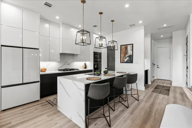 a living room with furniture a flat screen tv and a chandelier