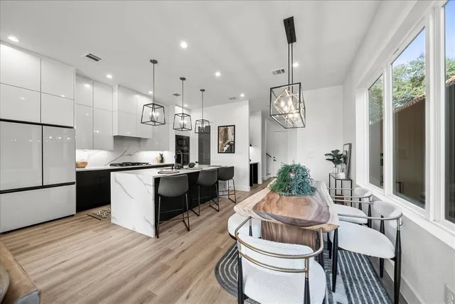 a kitchen with stainless steel appliances granite countertop a stove a sink and a refrigerator