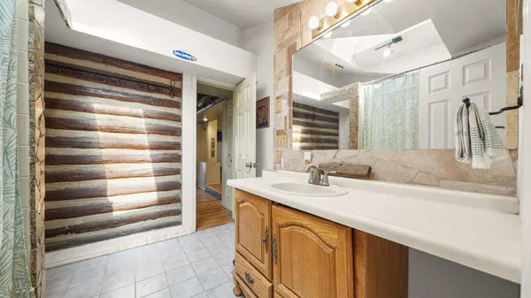 a bathroom with a granite countertop sink and a mirror