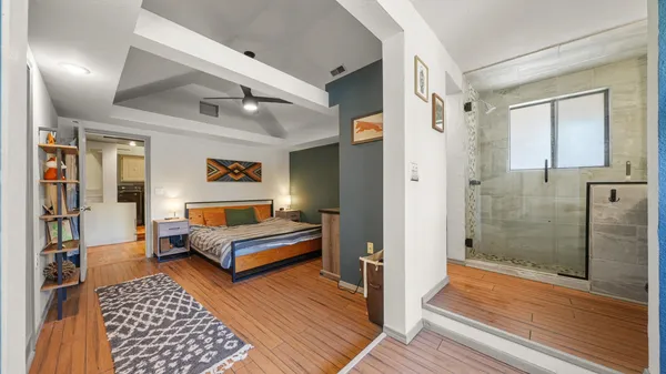 a spacious bedroom with a bed and wooden floor