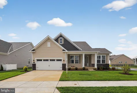 a front view of a house with a garden and yard