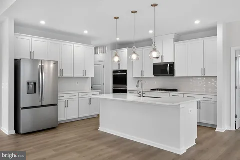 a kitchen with kitchen island a refrigerator sink and stove