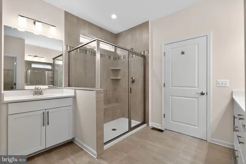 a bathroom with a shower sink and mirror