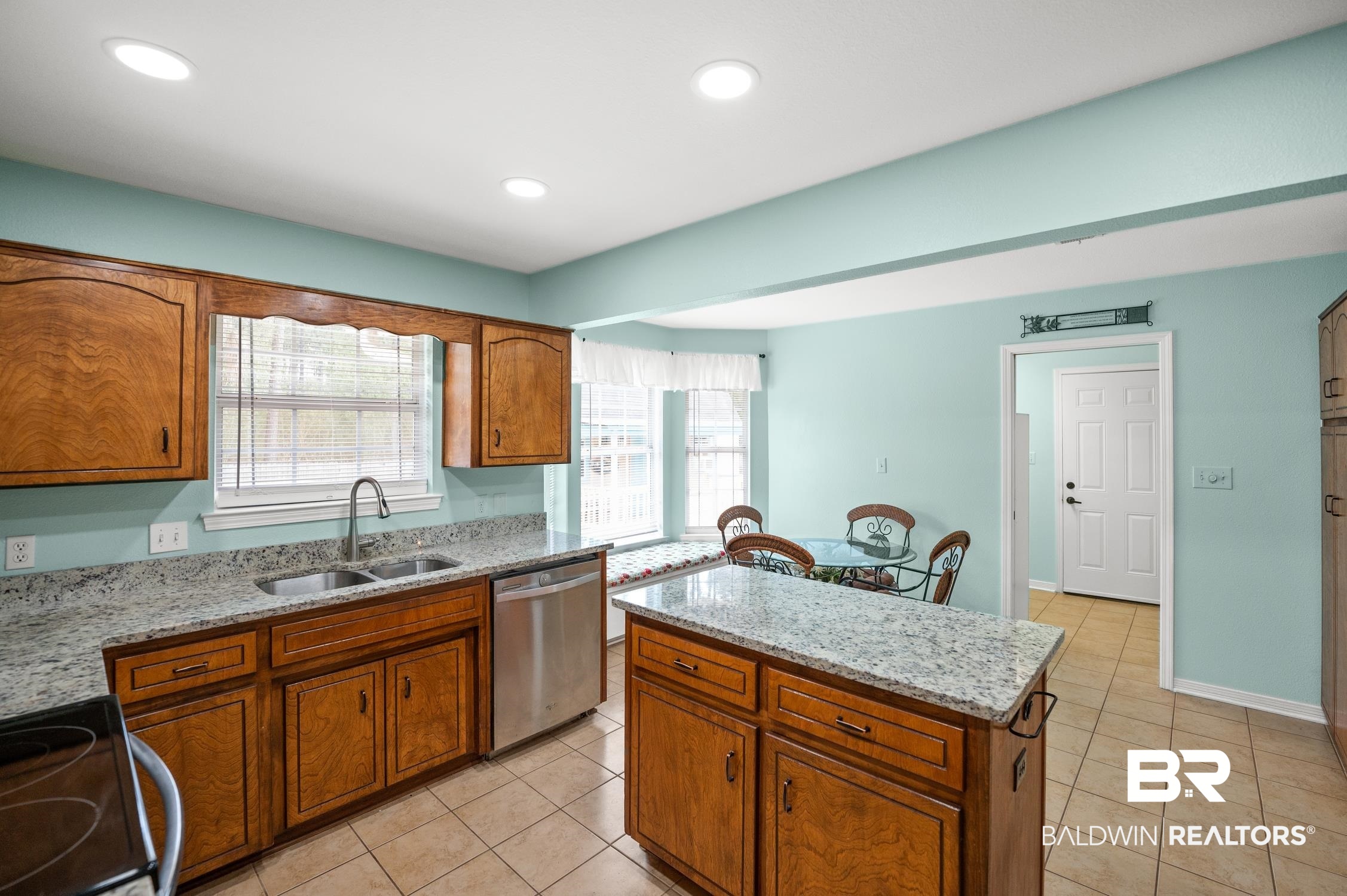 2553 Santa Rosa Drive Lillian, AL 36549 - Photo 20 of 51 Kitchen with brown cabinets, stainless steel appliances, a wealth of natural light, a sink, and a kitchen island