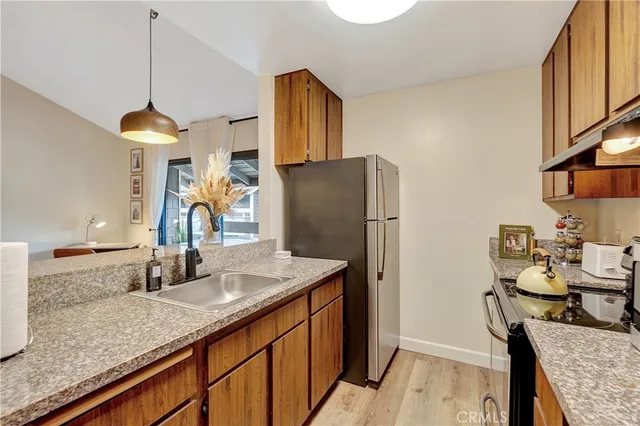 a kitchen with stainless steel appliances granite countertop a sink refrigerator and cabinets