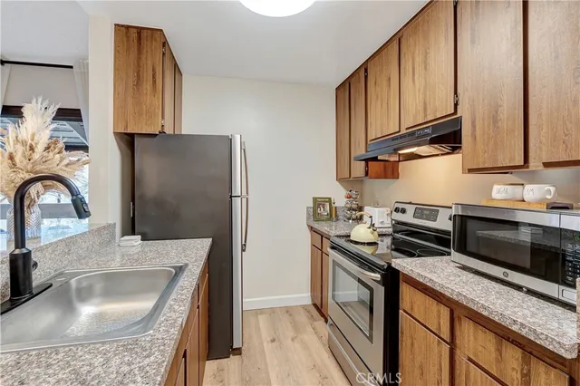 a kitchen with stainless steel appliances granite countertop a sink stove and refrigerator