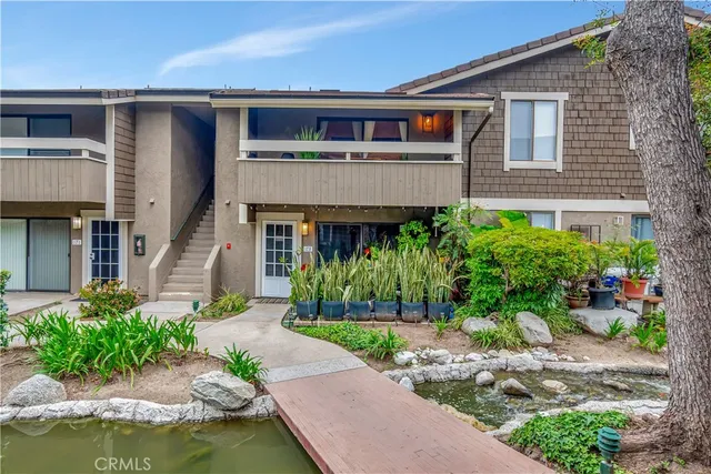 a front view of a house with a garden and plants