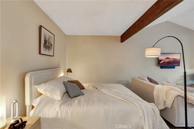 a bedroom with a bed and a painting on the wall