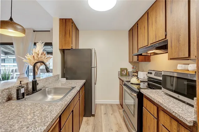 a kitchen with granite countertop a sink a stove and refrigerator