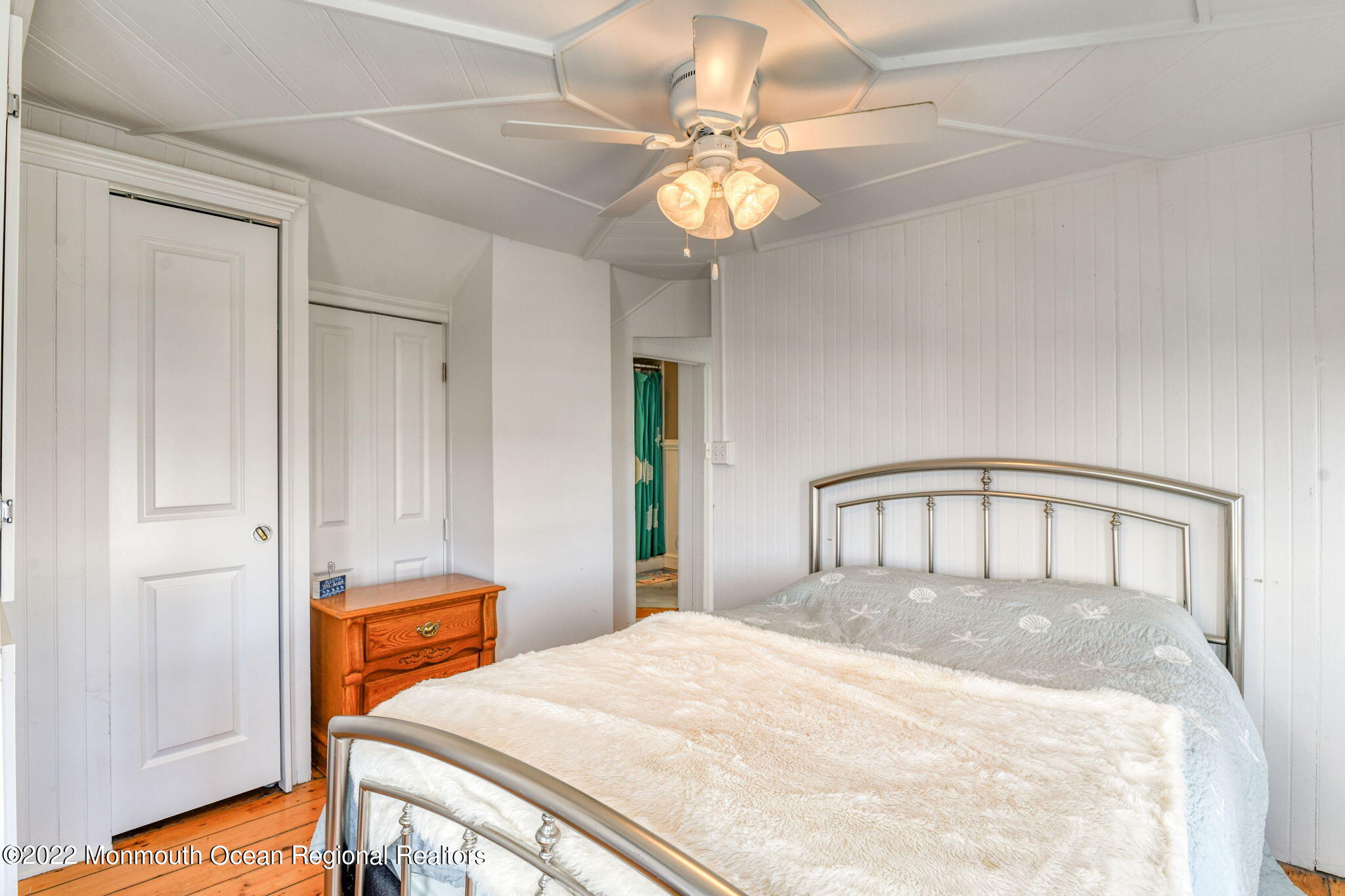 8 Surf Avenue, Unit 1 Ocean Grove, NJ 07756 - Photo 18 of 28 a bedroom with a bed and a chandelier