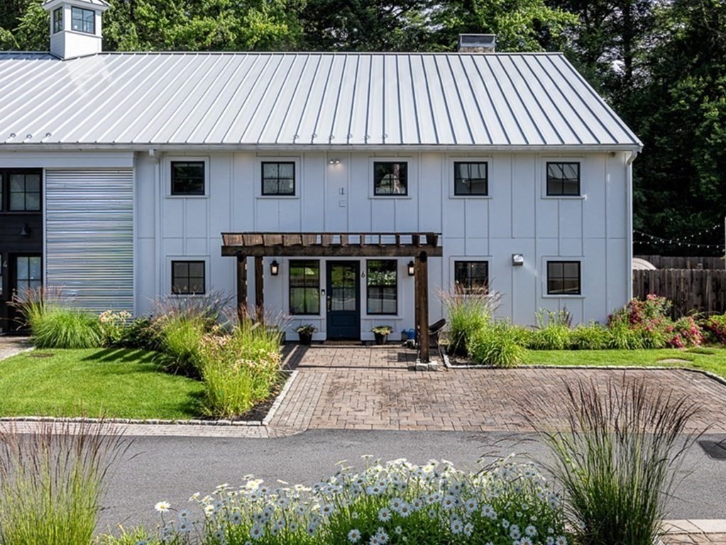 a front view of a house with a garden and plants
