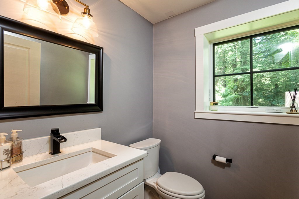 6 Twin Hills Farm Road, Unit 2 Rowley, MA 01969 - Photo 13 of 42 a bathroom with a toilet sink and mirror