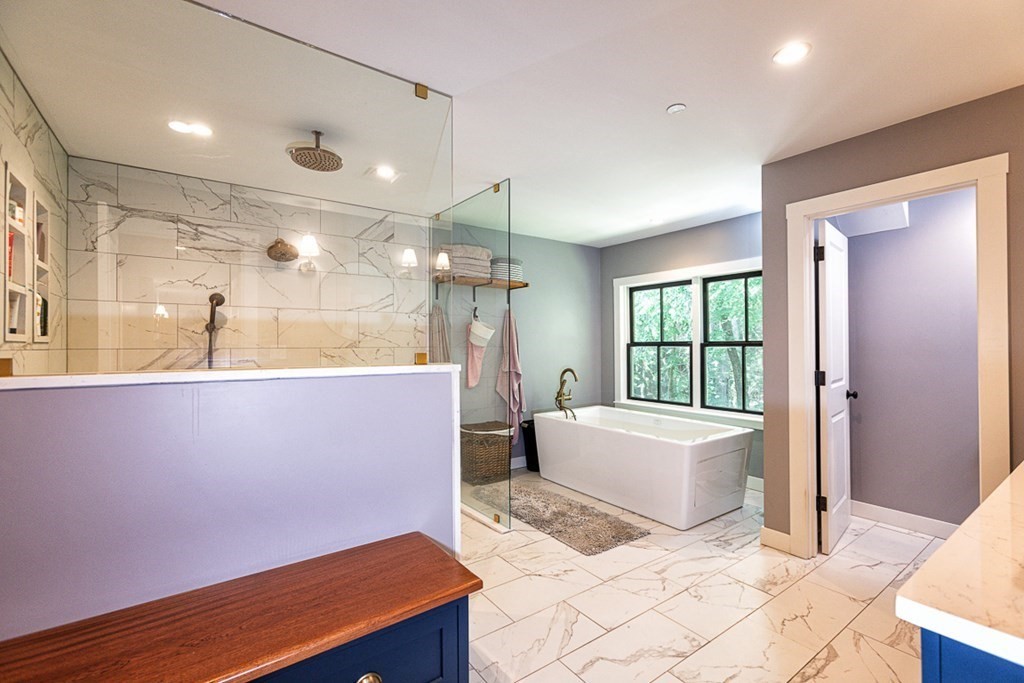 6 Twin Hills Farm Road, Unit 2 Rowley, MA 01969 - Photo 20 of 42 a spacious bathroom with a granite countertop sink a mirror and a bathtub