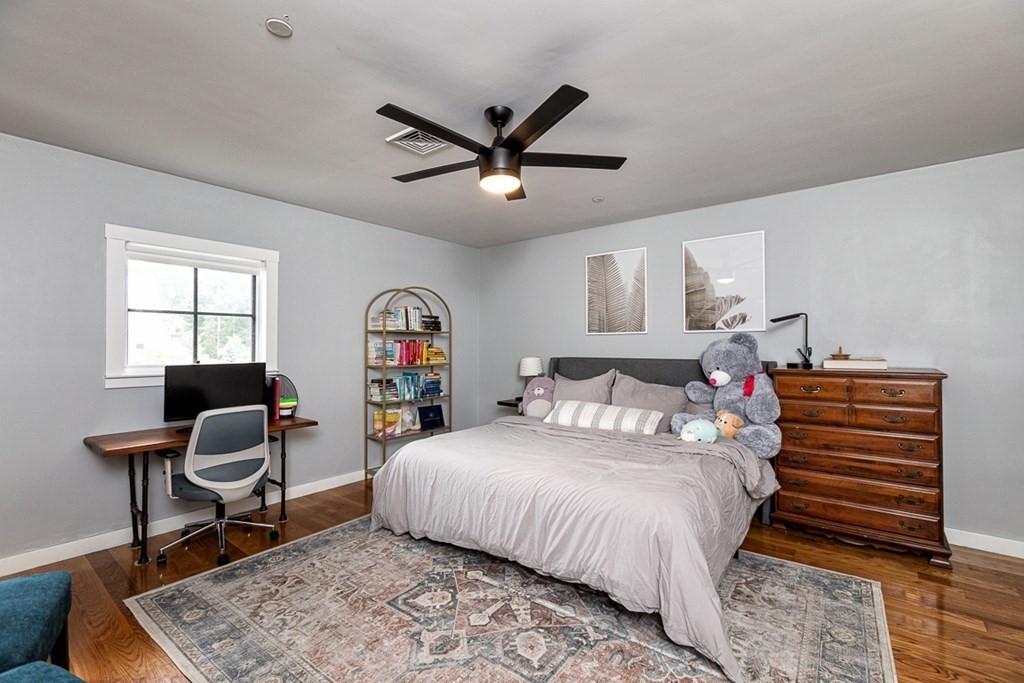 6 Twin Hills Farm Road, Unit 2 Rowley, MA 01969 - Photo 25 of 42 a bedroom with a bed a desk and chair with the wooden floor