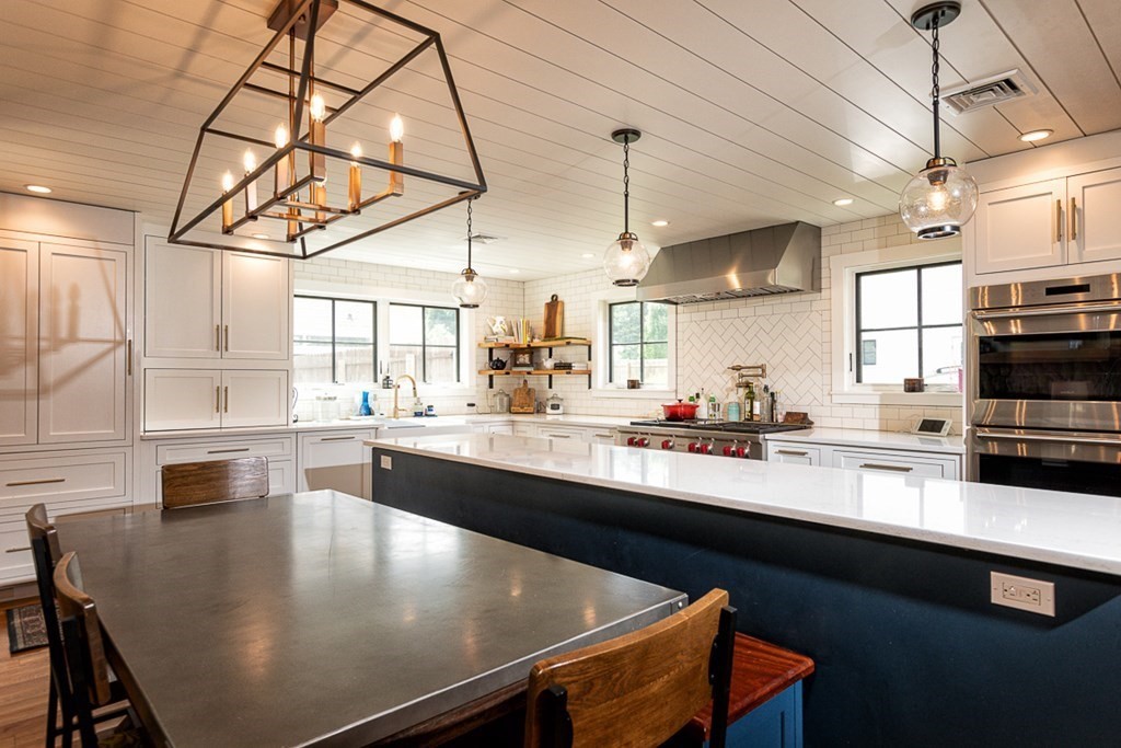 6 Twin Hills Farm Road, Unit 2 Rowley, MA 01969 - Photo 6 of 42 a kitchen with stainless steel appliances a table chairs in it and wooden floors