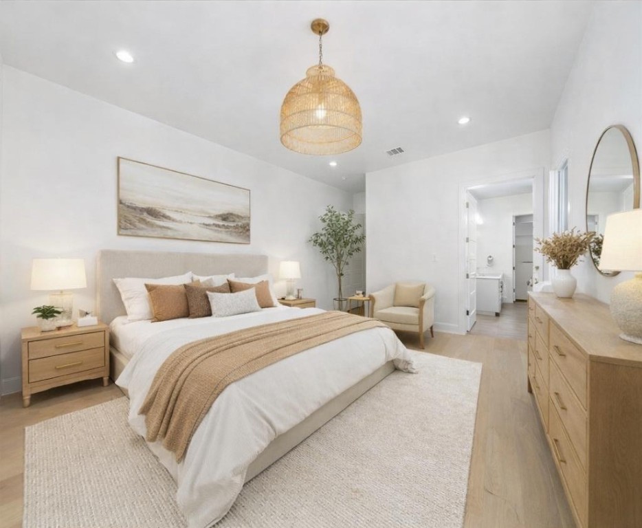 102 Mountain Home Road Horseshoe Bay, TX 78657 - Photo 11 of 32 a spacious bedroom with a bed and a chandelier