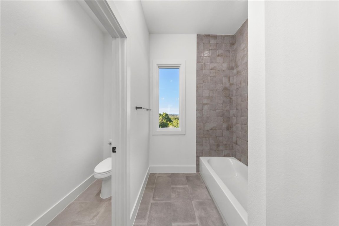 102 Mountain Home Road Horseshoe Bay, TX 78657 - Photo 20 of 32 a bathroom with a granite countertop bathtub shower