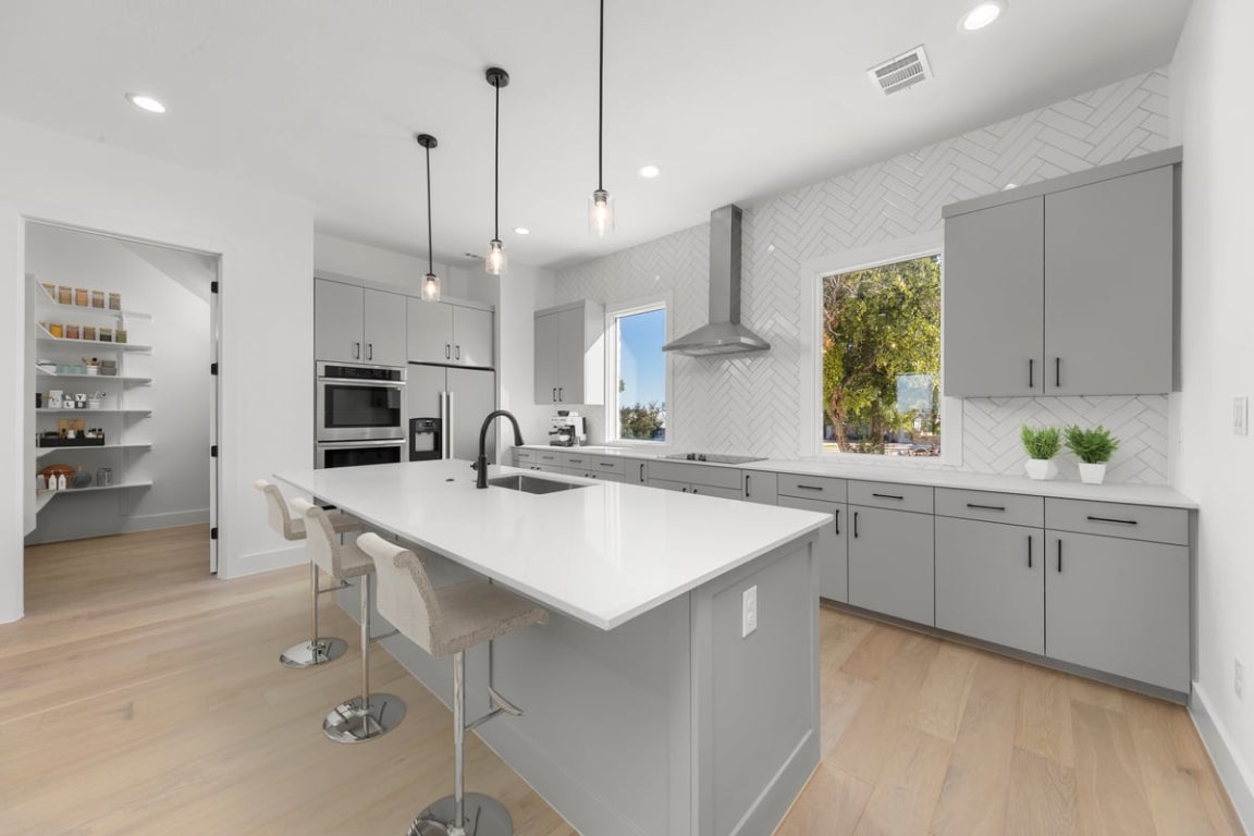 102 Mountain Home Road Horseshoe Bay, TX 78657 - Photo 8 of 32 a kitchen with white cabinets appliances and a window