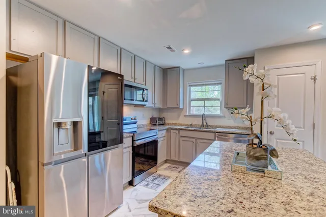 a kitchen with kitchen island granite countertop a refrigerator stove sink and dishwasher
