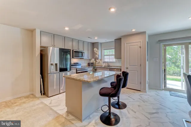 a kitchen with refrigerator and chairs
